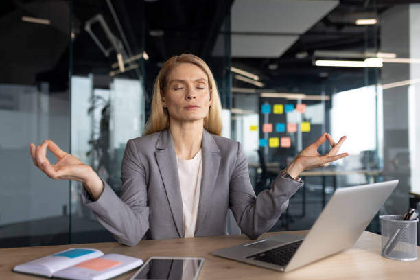 istock Mature businesswoman practicing mindfulness meditation at modern office workspace 2197444808