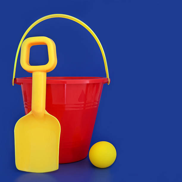 Summer beach bucket spade and ball fun seaside beach vacation toys. Childish holiday symbols in vivid red and yellow for travel vacation fun on blue background. Primary colors.