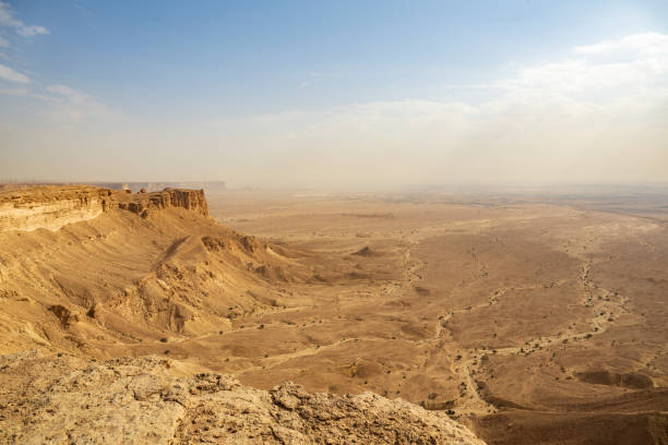 Panoramic perspective from Tuwaiq Escarpment also known as Jebel Fihrayn, looking out at ancient ocean bed, now desert plain, 300 meters below.