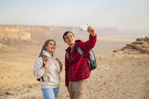 istock Active vacationers taking selfie at Edge of the World 2197447703