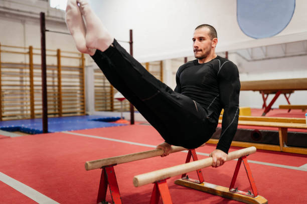 A determined woman performing bench abs exercises on a bench in a gym, focusing on a healthy and active lifestyle. She demonstrates strength and commitment to fitness in a modern and professional workout setting. Focused female athlete doing bench jackknives in a fitness center.