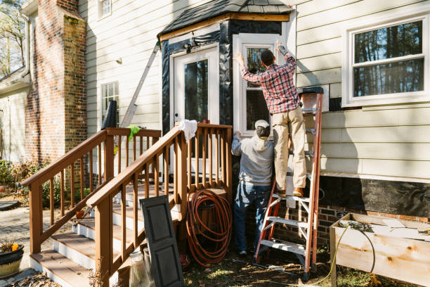 istock Construction workers repairing the siding of a house 2197452147