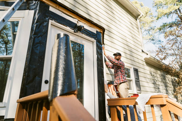 istock Construction workers repairing the siding of a house 2197454429