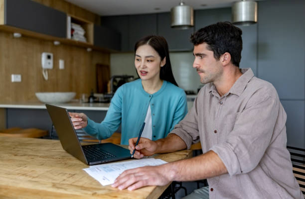istock Multiracial couple at home paying bills online 2197455439