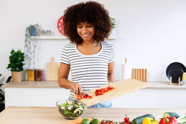 istock Young woman preparing a healthy salad in her modern kitchen 2197456028