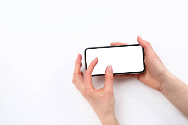 istock Smartphone in female hands on wooden background 2197458208