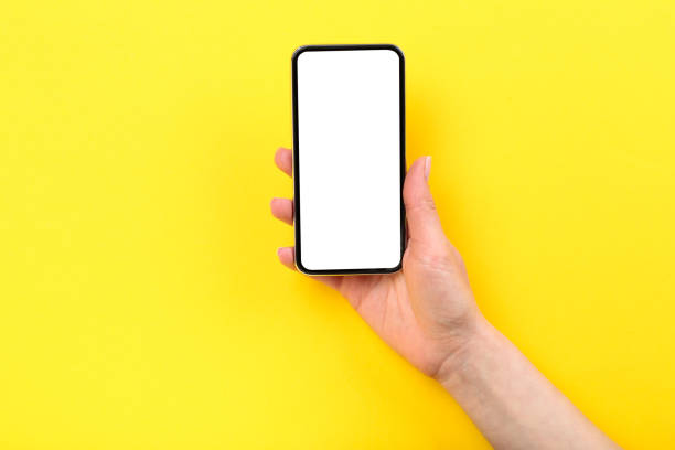 istock Smartphone in female hand on yellow background 2197458297