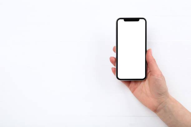 istock Smartphone in female hand on wooden background 2197459385