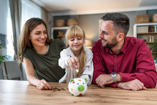 istock Daughter inserting coins in a piggybank 2197460018