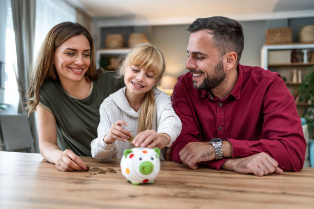 istock Daughter inserting coins in a piggybank 2197460044