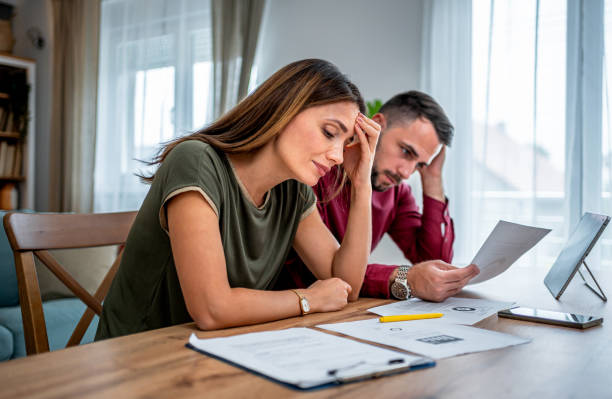 Young couple feeling worried while trying to get their finances in order