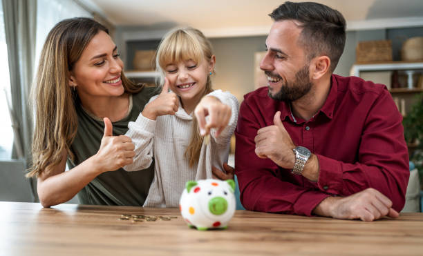 istock Daughter inserting coins in a piggybank 2197460917