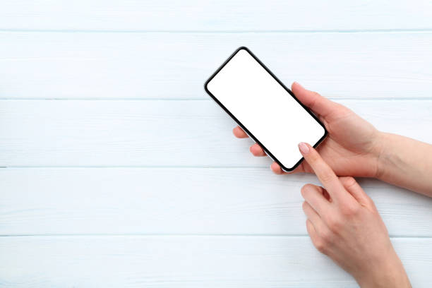 istock Smartphone in female hands on wooden background 2197461162