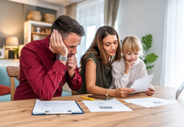 istock Young family with daughter going over finances at home 2197461291