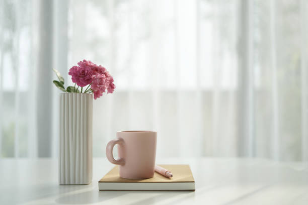istock Pink cup and rose, by the window with white curtain, cozy workspace 2197462189