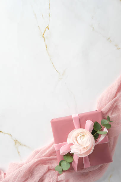 istock Elegant pink gift box decorated flower bud and eucalyptus leaf on pink fabric on marble background. Happy Mothers Day concept. 2197463120