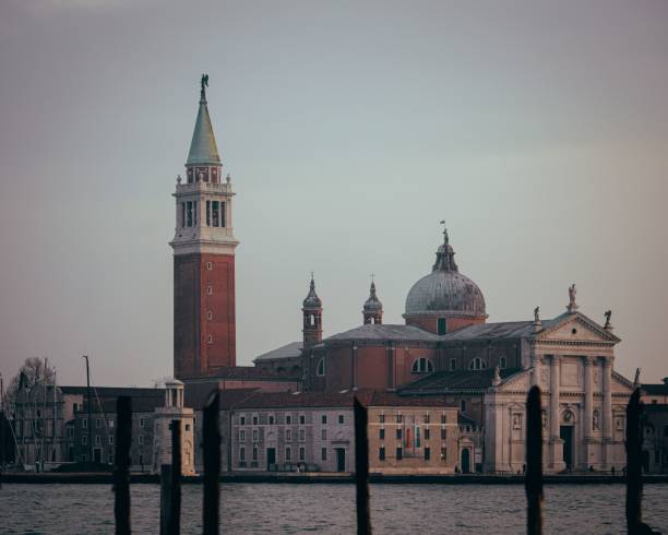 Scenic view of San Giorgio Maggiore in Venice with its iconic bell tower and dome against a serene sky, capturing the essence of Italian architecture.