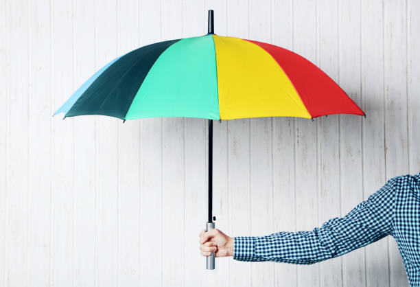 istock Colorful umbrella in male hand on wall paneling background 2197467084