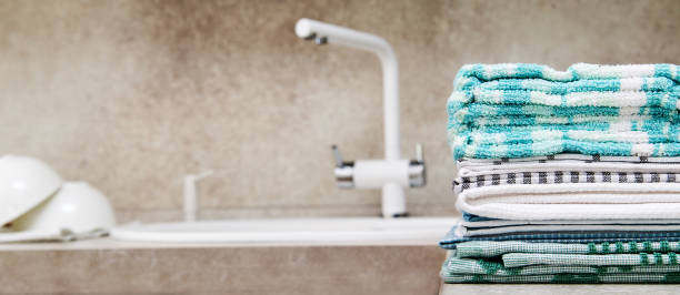 istock stack of colorful kitchen towels on the kitchen table next to the sink. 2197467489