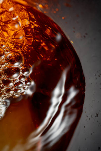 istock Golden drink is poured into the glass, creating beautiful waves and splashes. 2197468651
