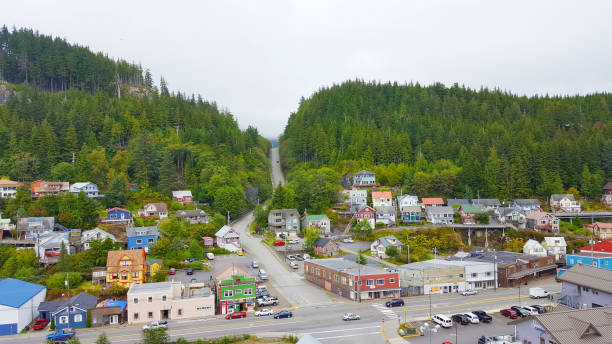 Colorful shops and rustic buildings line the charming streets of Juneau, Alaska, nestled between towering mountains and the glistening waterfront.