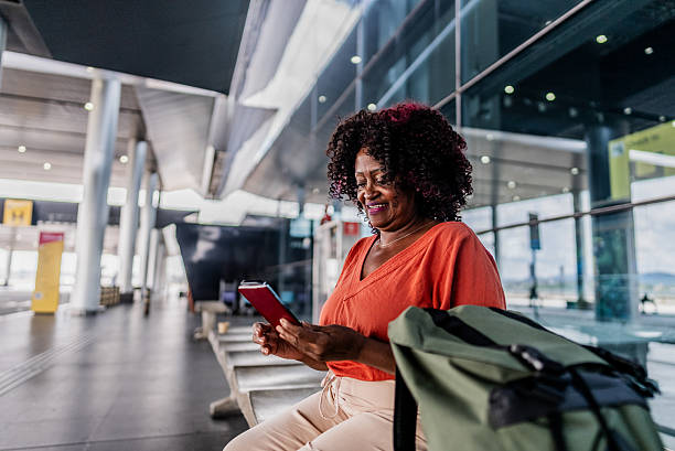 istock Senior woman using mobile phone on a airport 2197473616