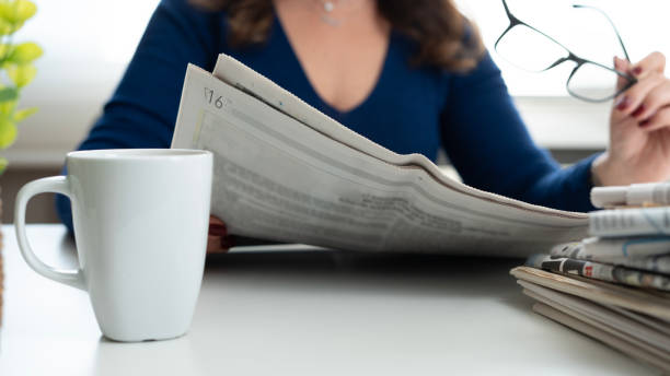 istock woman reading newspaper at office 2197476007