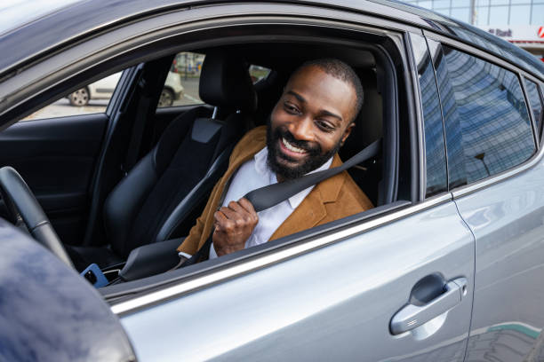 istock Smiling man securing seatbelt while seated in a modern car 2197479959