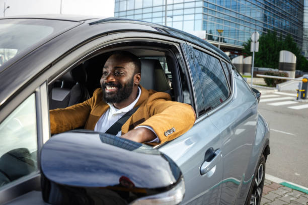 istock Smiling man enjoying driving a car in an urban environment 2197480061
