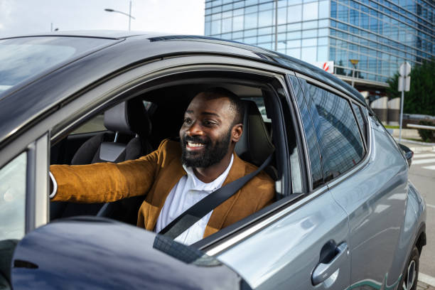 istock Man driving a car in an urban area with a cheerful expression 2197480077