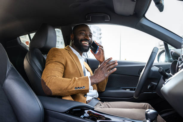 istock Smiling businessman talking on the phone while sitting inside a modern car 2197480656