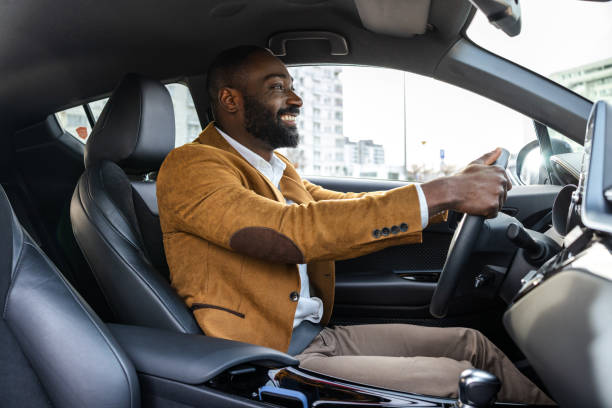 istock Smiling man driving a car in an urban environment during daytime hours 2197480722