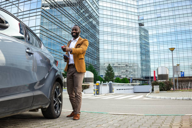 istock Smiling businessman unlocking car with remote in urban office area 2197480768
