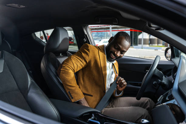 istock Man fastening seatbelt inside a modern car preparing for safe driving 2197480894