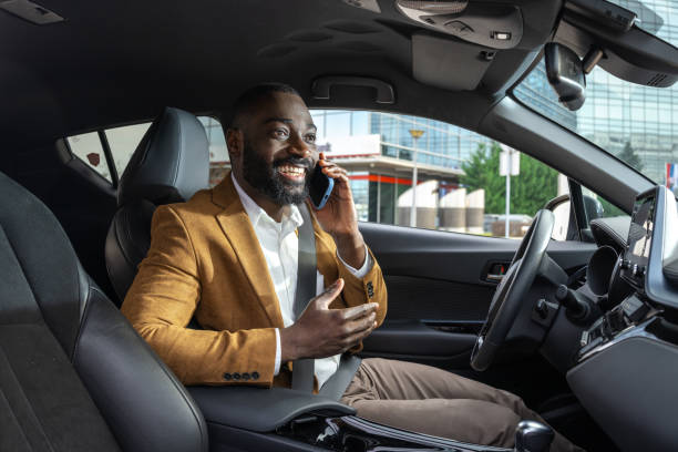 istock Smiling businessman talking on the phone while sitting inside a modern car 2197480958