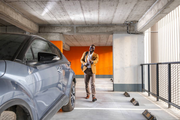 istock Smiling businessman unlocking car with remote in urban parking garage 2197481116
