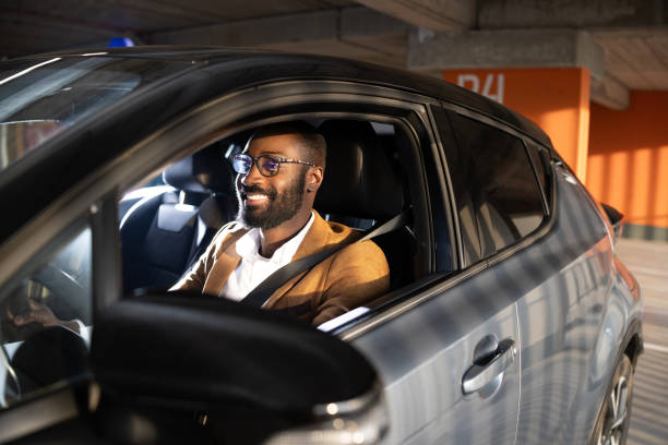 istock Business professional smiling confidently while driving a luxury car inside a garage 2197481396