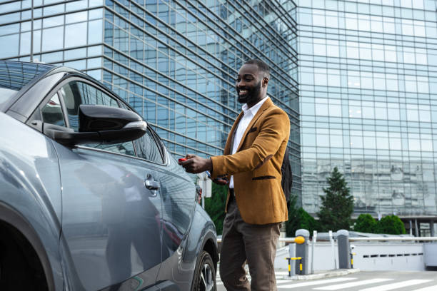 Professional African American man unlocking car in a modern urban environment