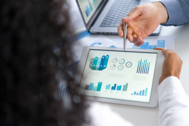 istock Close up of two people looking at financial data with graphs and charts. 2197481512