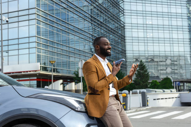 istock Businessman talking on phone while standing by his car outside a corporate building 2197481587