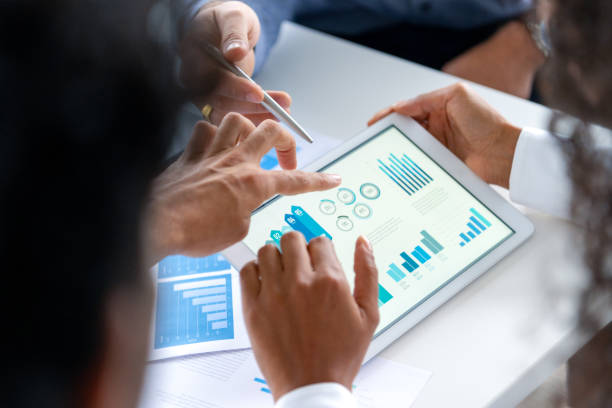 istock Close up of three people looking at financial data with graphs and charts. 2197481643