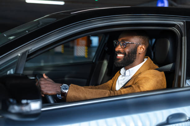 istock Business professional smiling confidently while driving a luxury car inside a garage 2197481648