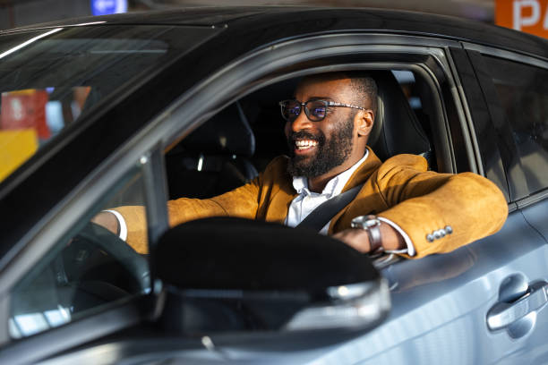 istock Happy man in stylish jacket smiling while driving a modern car 2197481653