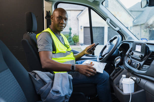 istock African American Delivery Driver Using Smartphone in Van 2197485848