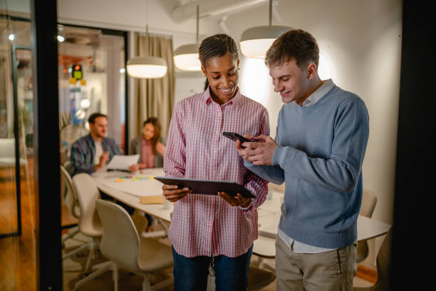 istock two multicultural colleague use clipboard and mobile phone at office 2197489768