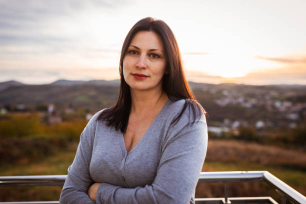 istock Smiling Woman Enjoying Sunset Outdoors With Scenic View 2197489893