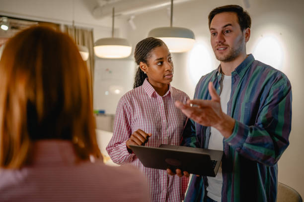 istock two diverse colleague use laptop and talk with client at office 2197491660