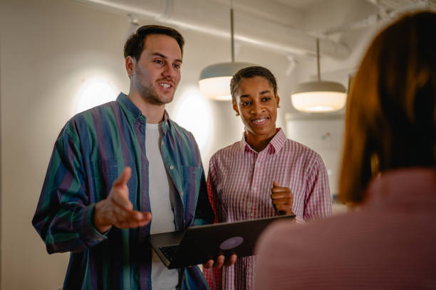 istock two diverse colleague use laptop and talk with client at office 2197491682
