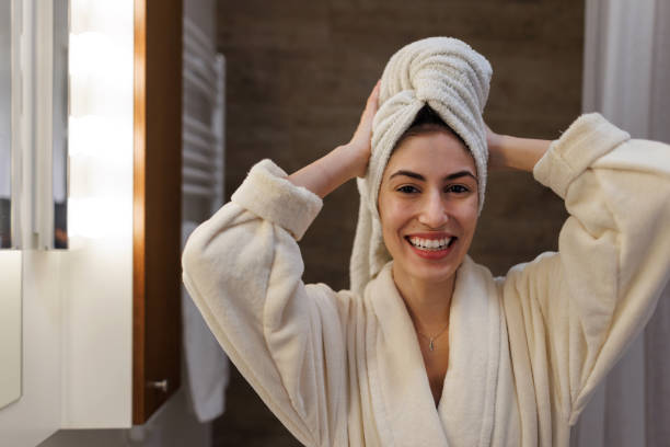 istock Young woman adjusting her towel on her head after shower 2197491997