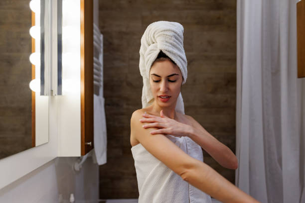 istock Young woman applying moisturizing cream after shower in bathroom 2197492044